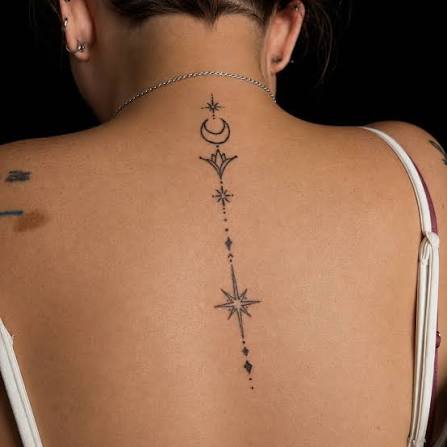 Fine-line celestial spine tattoo by Supremacy Ink